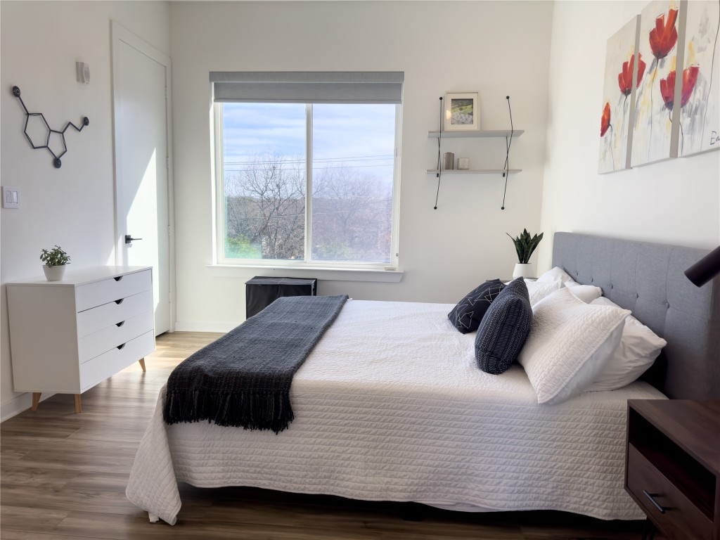 2804 South 1st Street, Unit 1301 Austin, TX 78704 - Photo 11 of 15 a bedroom with a bed and wooden floor