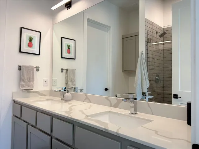 a bathroom with double vanity sinks and a large mirror