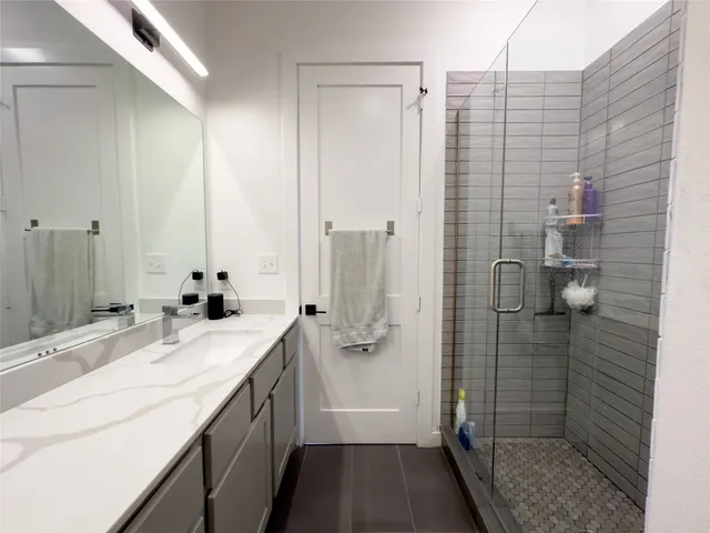 a bathroom with a granite countertop sink a shower and a mirror