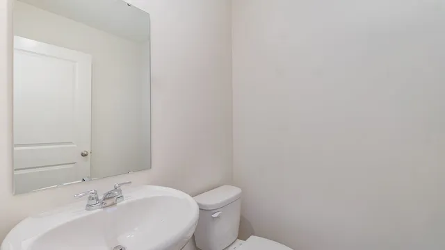 a bathroom with a toilet a sink and mirror