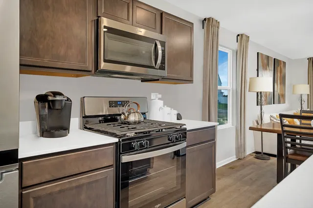 a kitchen with stainless steel appliances granite countertop a stove and a microwave