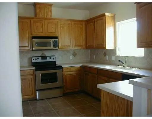 a kitchen with stainless steel appliances granite countertop a sink a stove a microwave and cabinets
