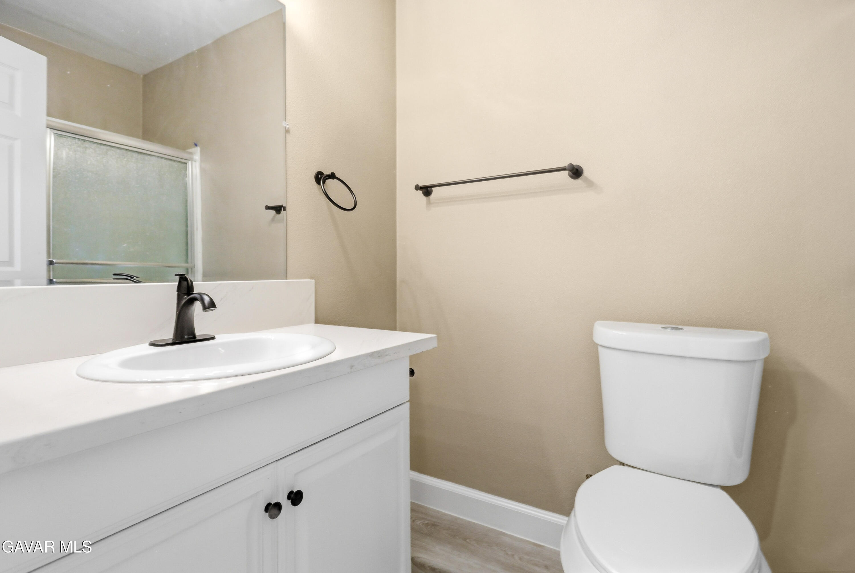 3340 West Roxbury Street Rosamond, CA 93560 - Photo 15 of 20 a bathroom with a toilet a sink and mirror