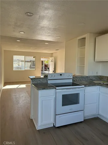 a kitchen with granite countertop a sink and cabinets