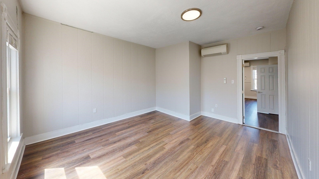 44 Morris Street, Unit 2 Boston, MA 02128 - Photo 17 of 23 an empty room with wooden floor and windows