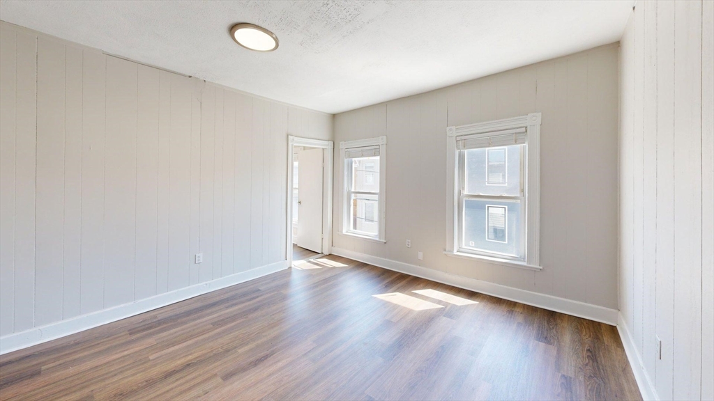 44 Morris Street, Unit 2 Boston, MA 02128 - Photo 19 of 23 an empty room with wooden floor and windows