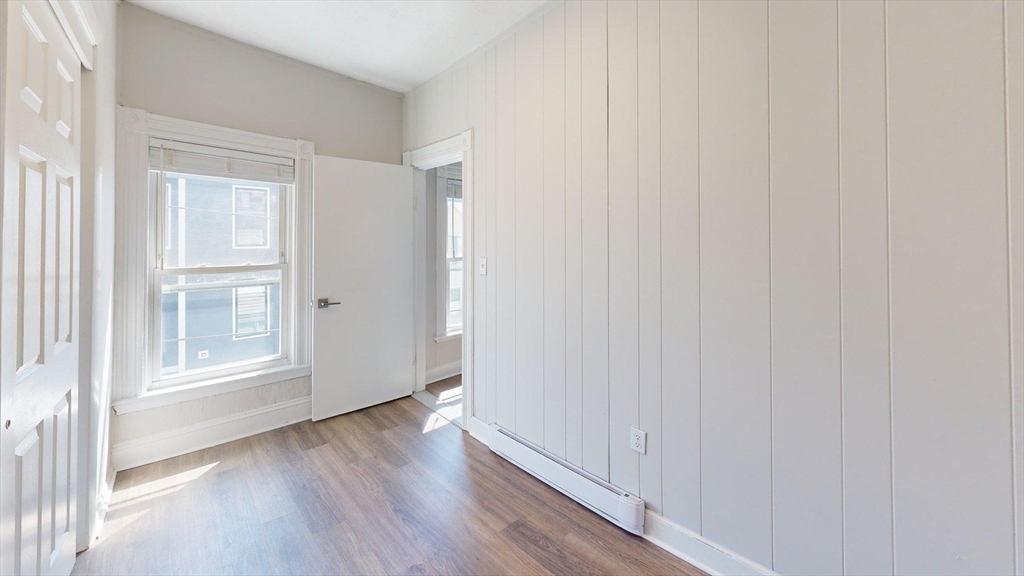 44 Morris Street, Unit 2 Boston, MA 02128 - Photo 20 of 23 an empty room with wooden floor and windows