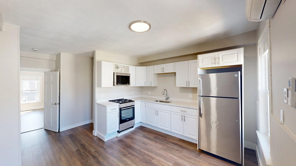 44 Morris Street, Unit 2 Boston, MA 02128 - Photo 2 of 23 a kitchen with white cabinets and stainless steel appliances