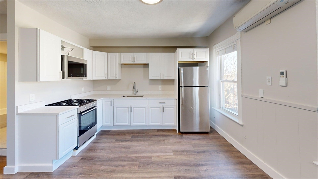 44 Morris Street, Unit 2 Boston, MA 02128 - Photo 22 of 23 a kitchen with a refrigerator stove top oven and cabinets