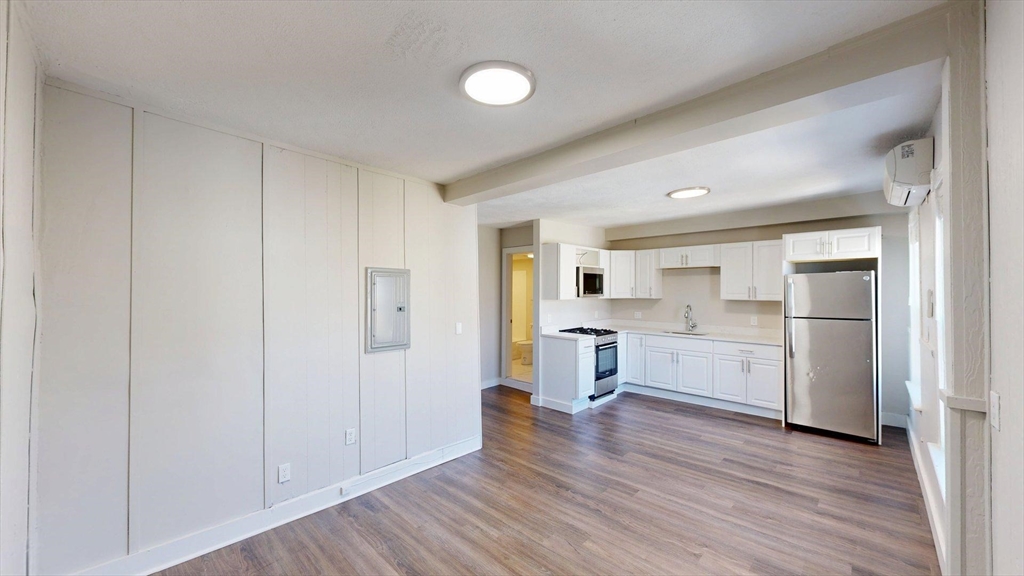 44 Morris Street, Unit 2 Boston, MA 02128 - Photo 4 of 23 a view of a kitchen with white cabinets and wooden floor