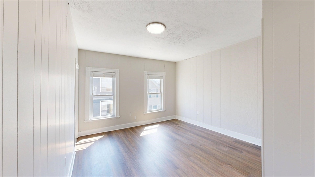 44 Morris Street, Unit 2 Boston, MA 02128 - Photo 9 of 23 an empty room with wooden floor and windows