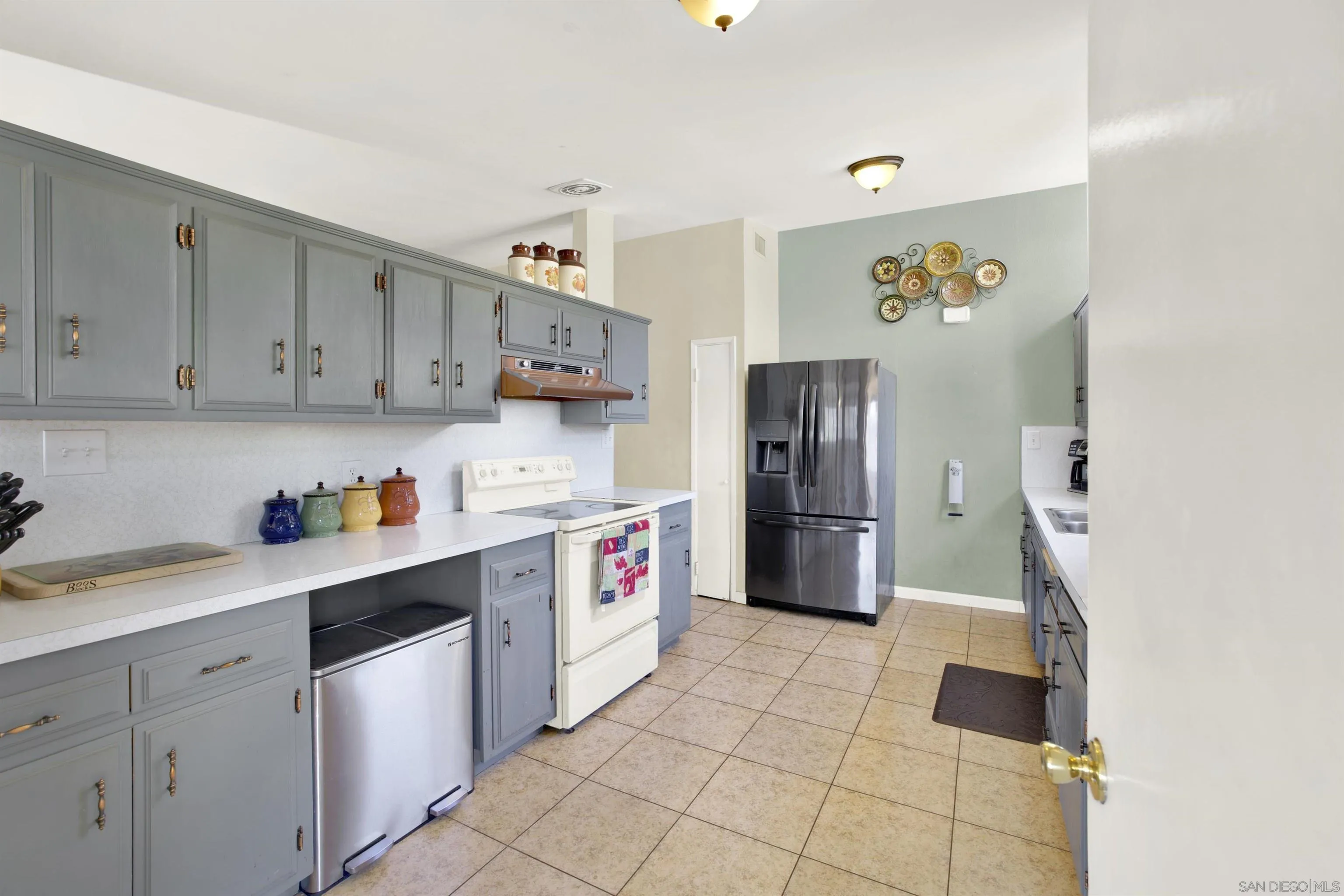 13951 Powers Road Poway, CA 92064 - Photo 4 of 27 a kitchen with a sink a refrigerator and cabinets