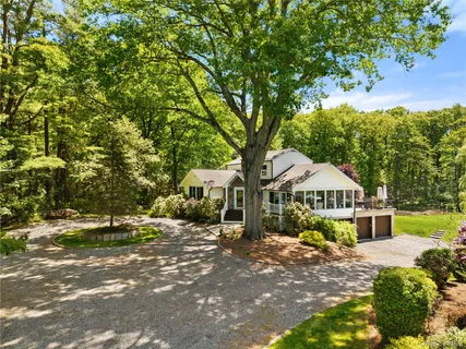 a view of a house with a tree in front of it