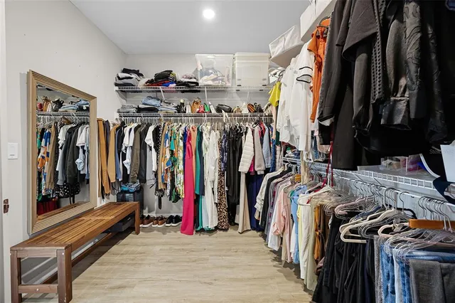a view of walk in closet with clothes and shoes
