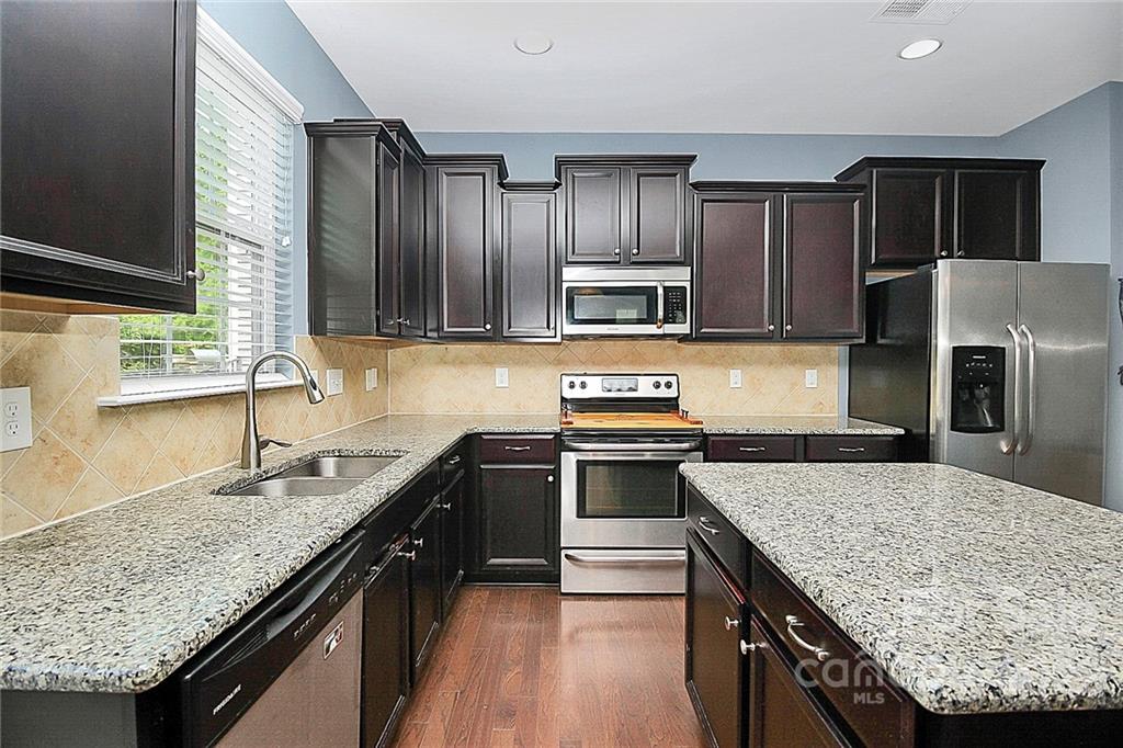 78134 Rillstone Drive Lancaster, SC 29720 - Photo 9 of 26 a kitchen with stainless steel appliances granite countertop a sink stove microwave and refrigerator