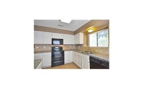 a kitchen with granite countertop a stove top oven and sink