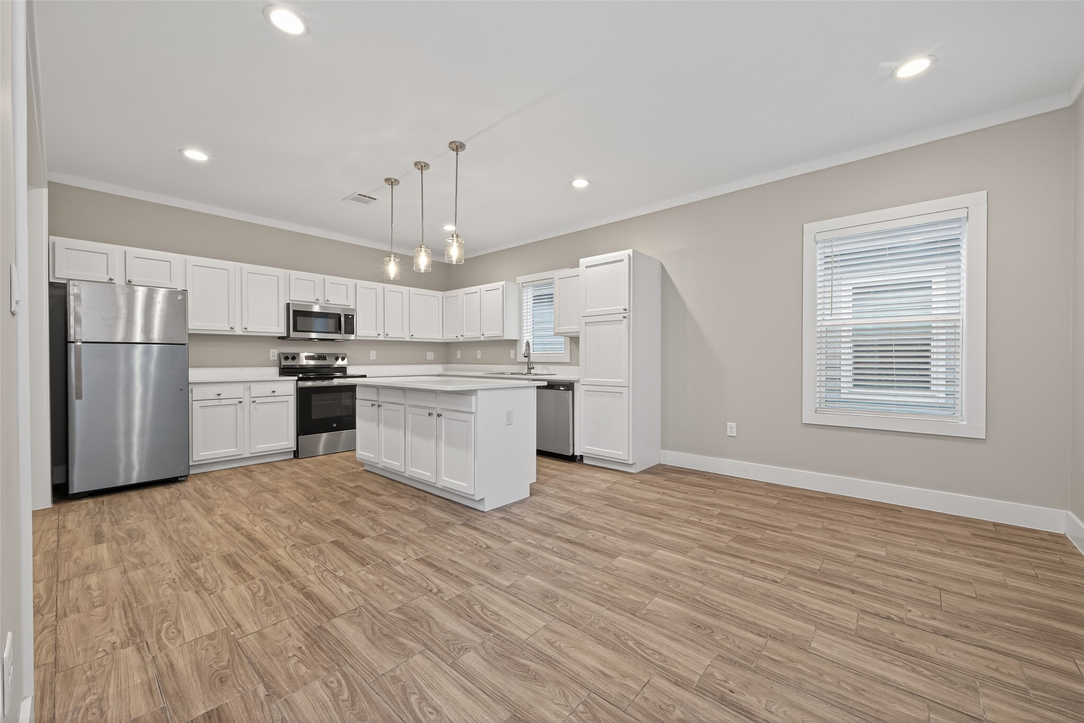 6605 Greenhurst Street Houston, TX 77091 - Photo 11 of 41 a kitchen with stainless steel appliances granite countertop a stove top oven a refrigerator and white cabinets with wooden floor