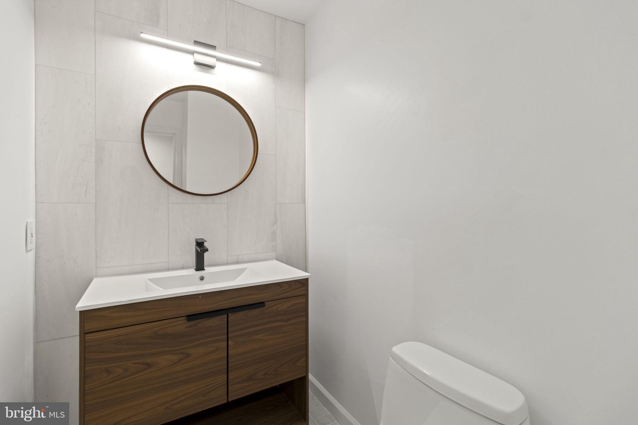 8800 Seven Locks Road Bethesda, MD 20817 - Photo 13 of 33 a bathroom with a toilet a sink and a mirror