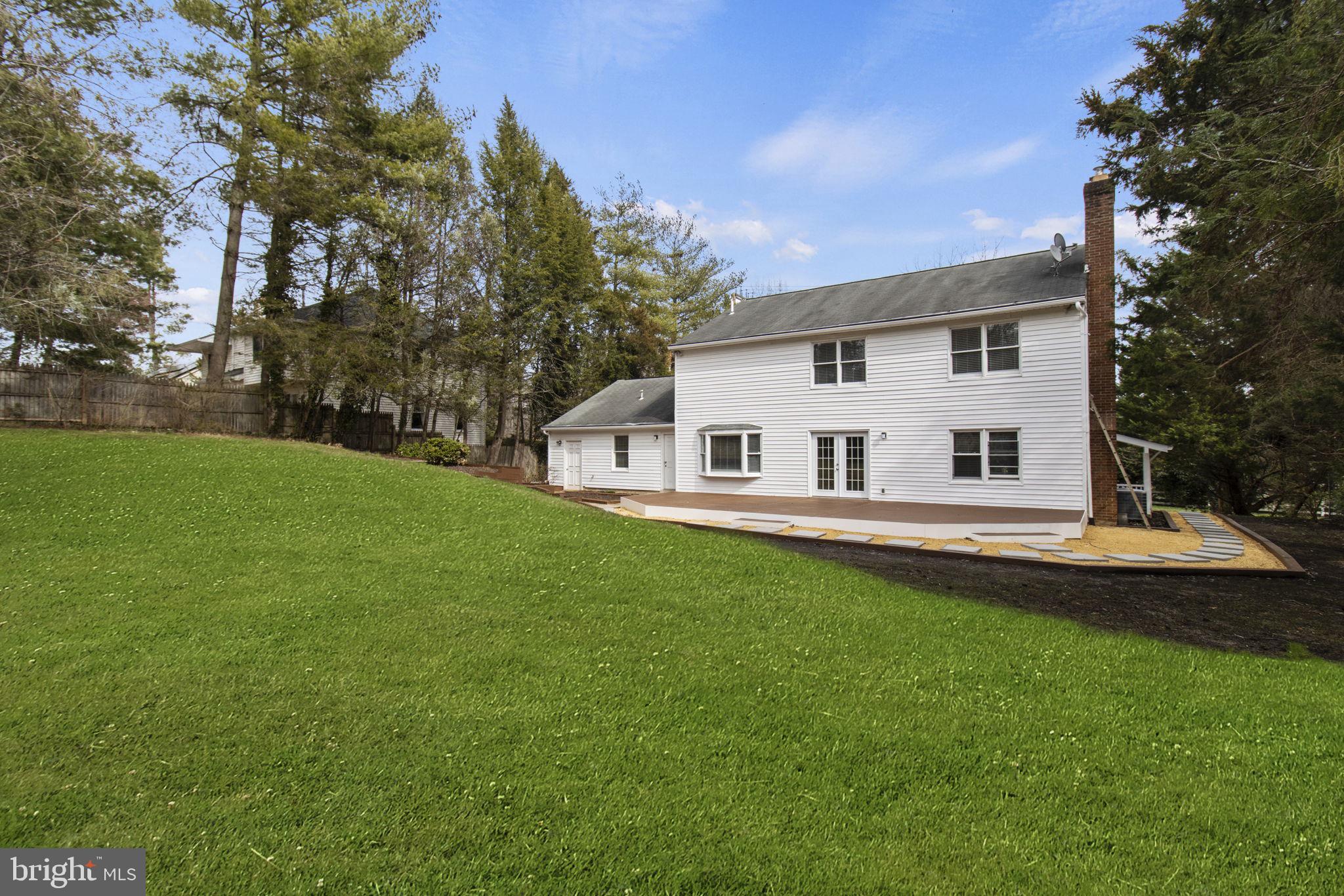 8800 Seven Locks Road Bethesda, MD 20817 - Photo 29 of 33 a view of a white house in front of a big yard with large trees