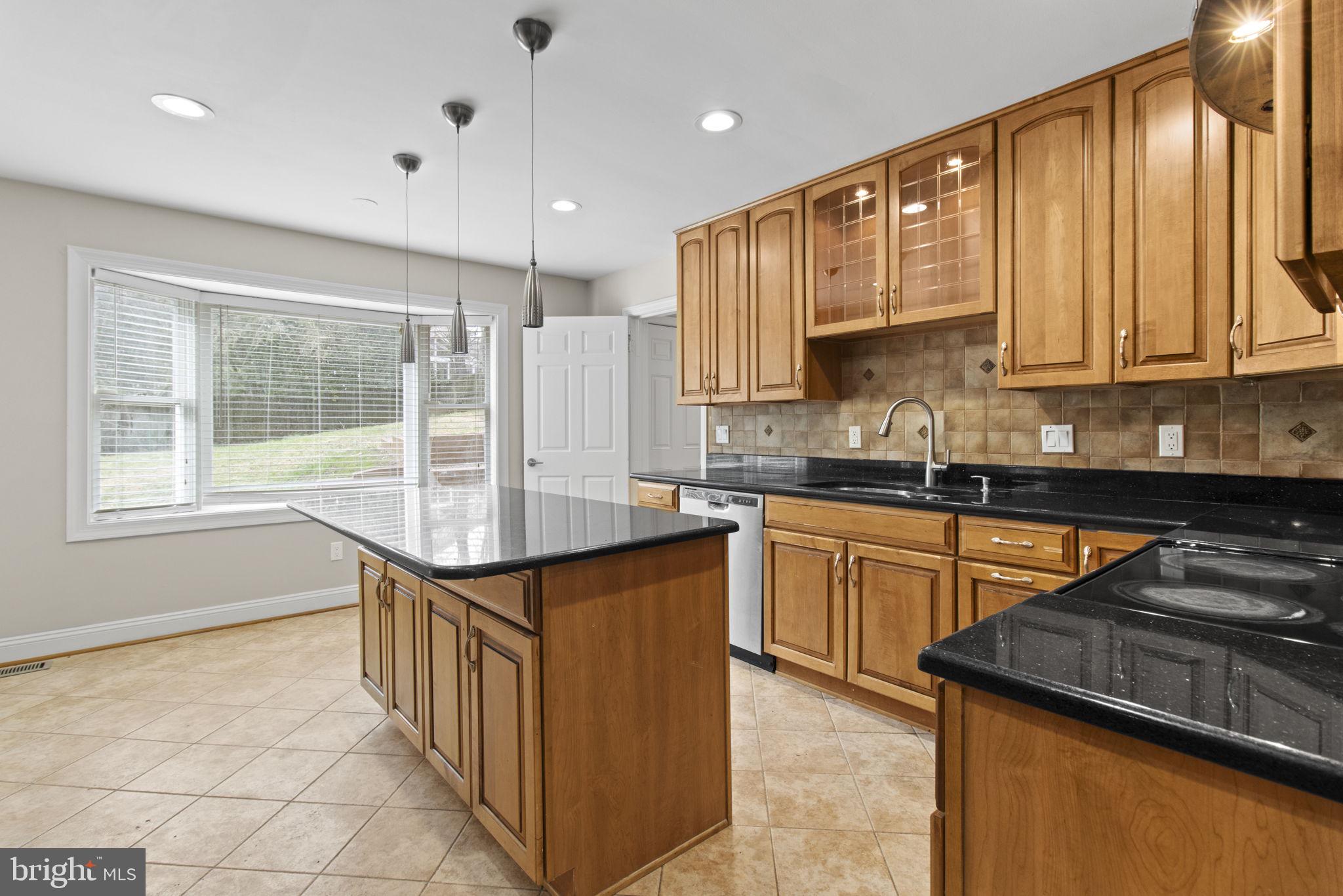 8800 Seven Locks Road Bethesda, MD 20817 - Photo 8 of 33 a kitchen with stainless steel appliances granite countertop a stove a sink and a microwave