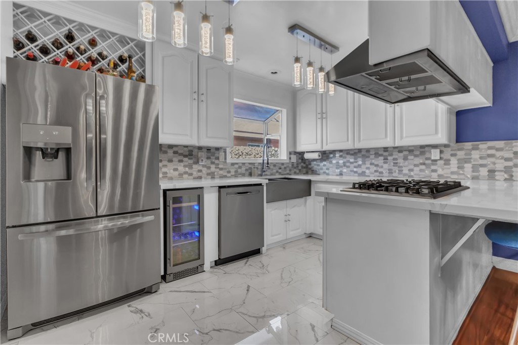 1324 East Turmont Street Carson, CA 90746 - Photo 16 of 47 a kitchen with stainless steel appliances granite countertop a refrigerator a stove a sink and a microwave