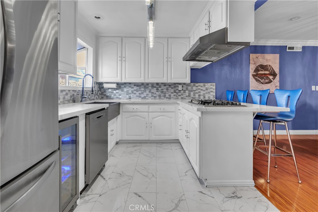 1324 East Turmont Street Carson, CA 90746 - Photo 17 of 47 a kitchen with stainless steel appliances granite countertop a sink stove and cabinets
