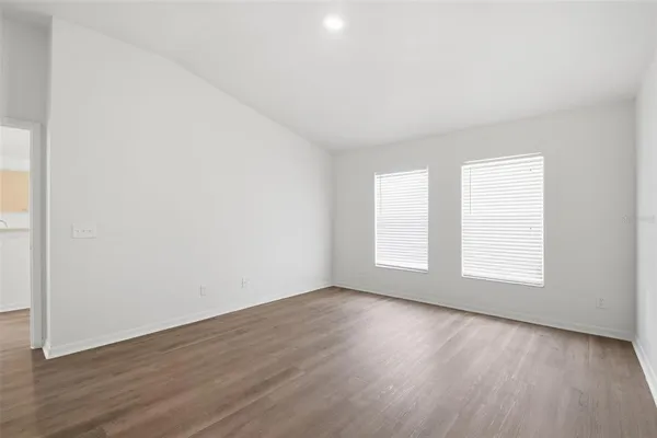 an empty room with wooden floor and window