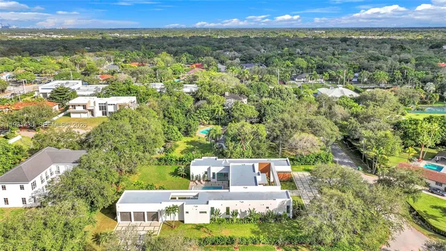 an aerial view of residential houses with outdoor space and trees