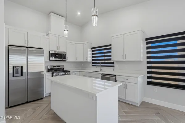 a kitchen with granite countertop a sink a stove and cabinets