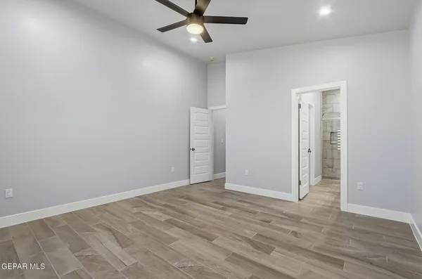 a view of an empty room with wooden floor and closet