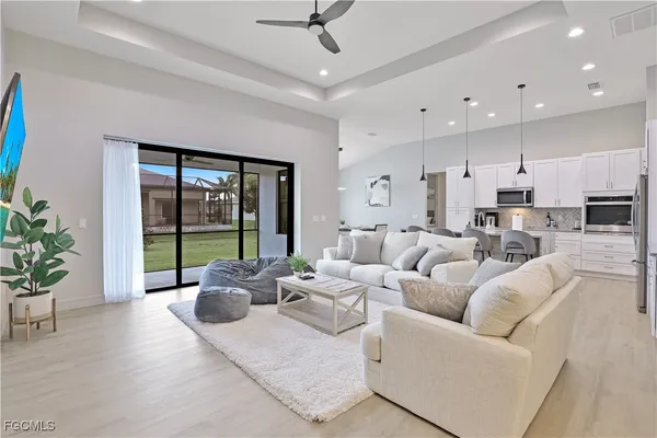 a living room with furniture potted plant and a large window