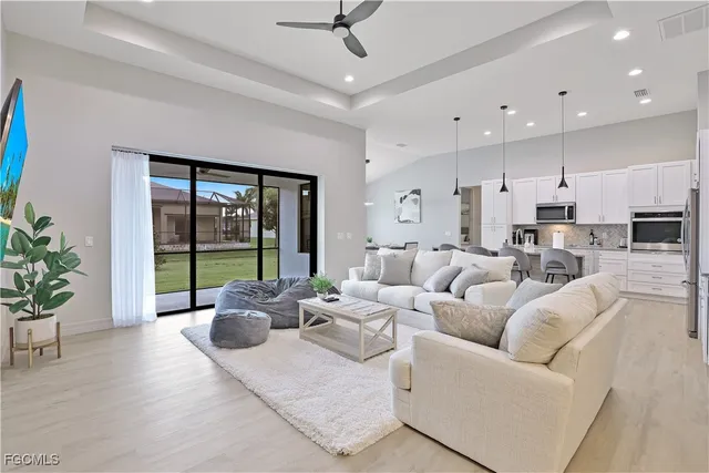 a living room with furniture potted plant and a large window