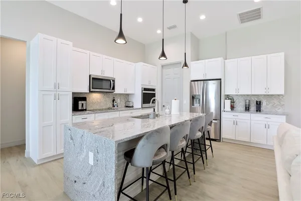 a kitchen with kitchen island granite countertop a center island a sink stainless steel appliances and cabinets