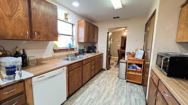 a kitchen with stainless steel appliances a sink wooden floor cabinets and a counter top space
