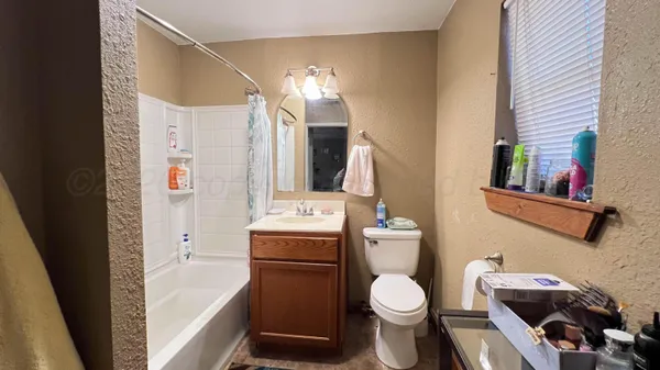 a bathroom with a granite countertop toilet sink and mirror