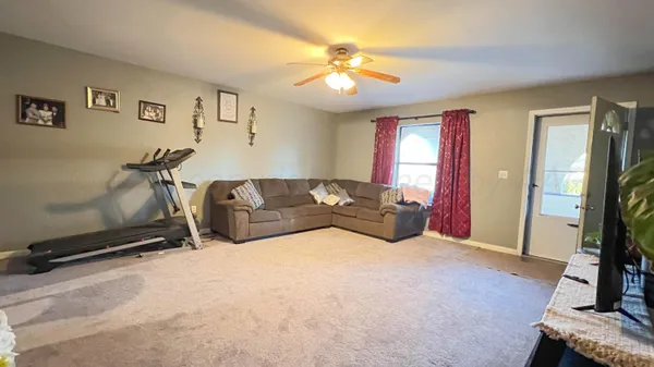 a living room with furniture gym equipment and a flat screen tv