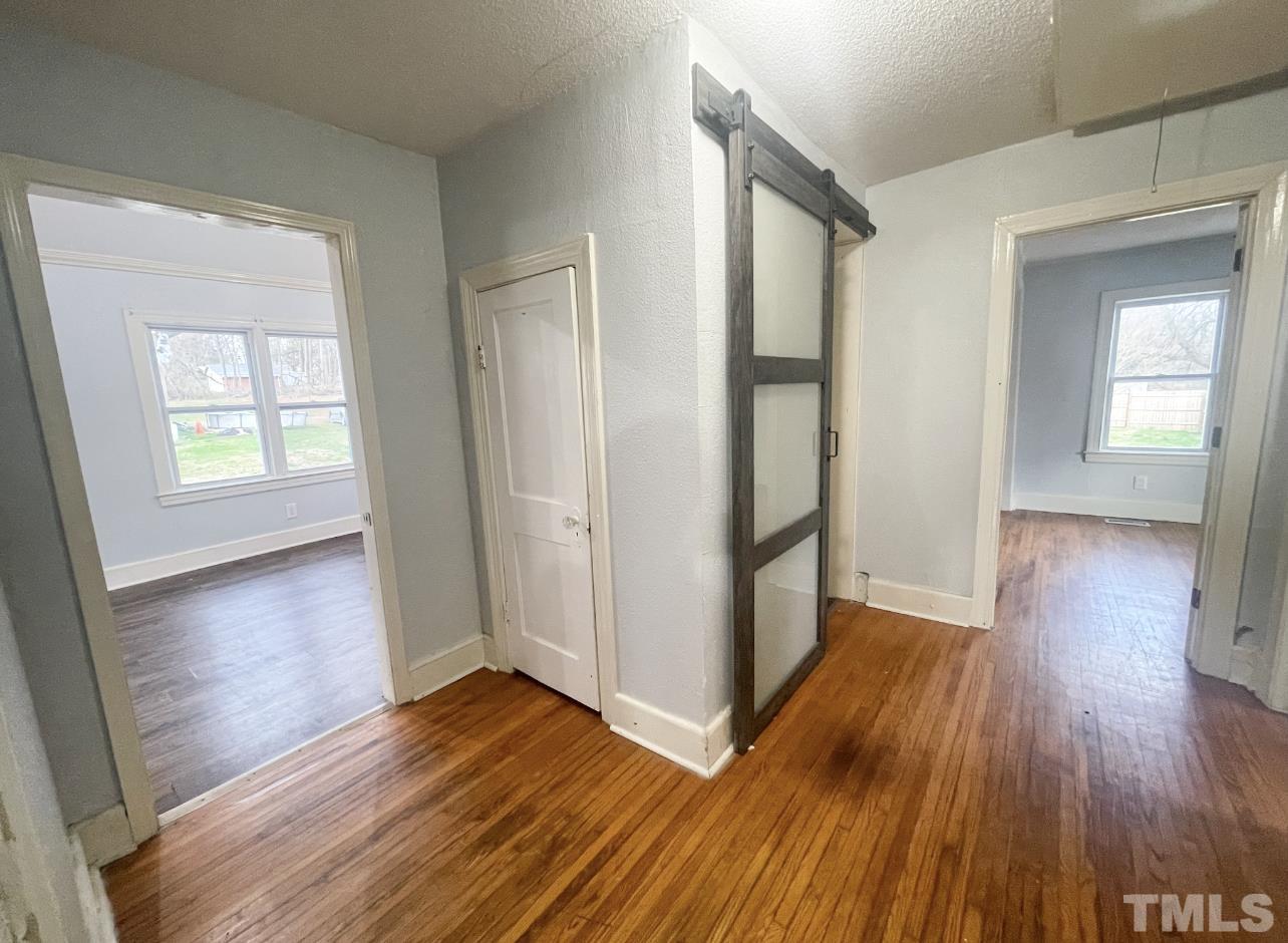 1240 Pointer Street Roxboro, NC 27573 - Photo 13 of 20 an empty room with wooden floor and windows