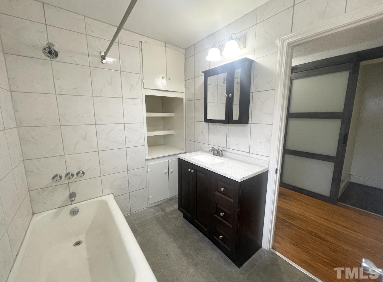 1240 Pointer Street Roxboro, NC 27573 - Photo 16 of 20 a bathroom with a double vanity sink mirror and bathtub