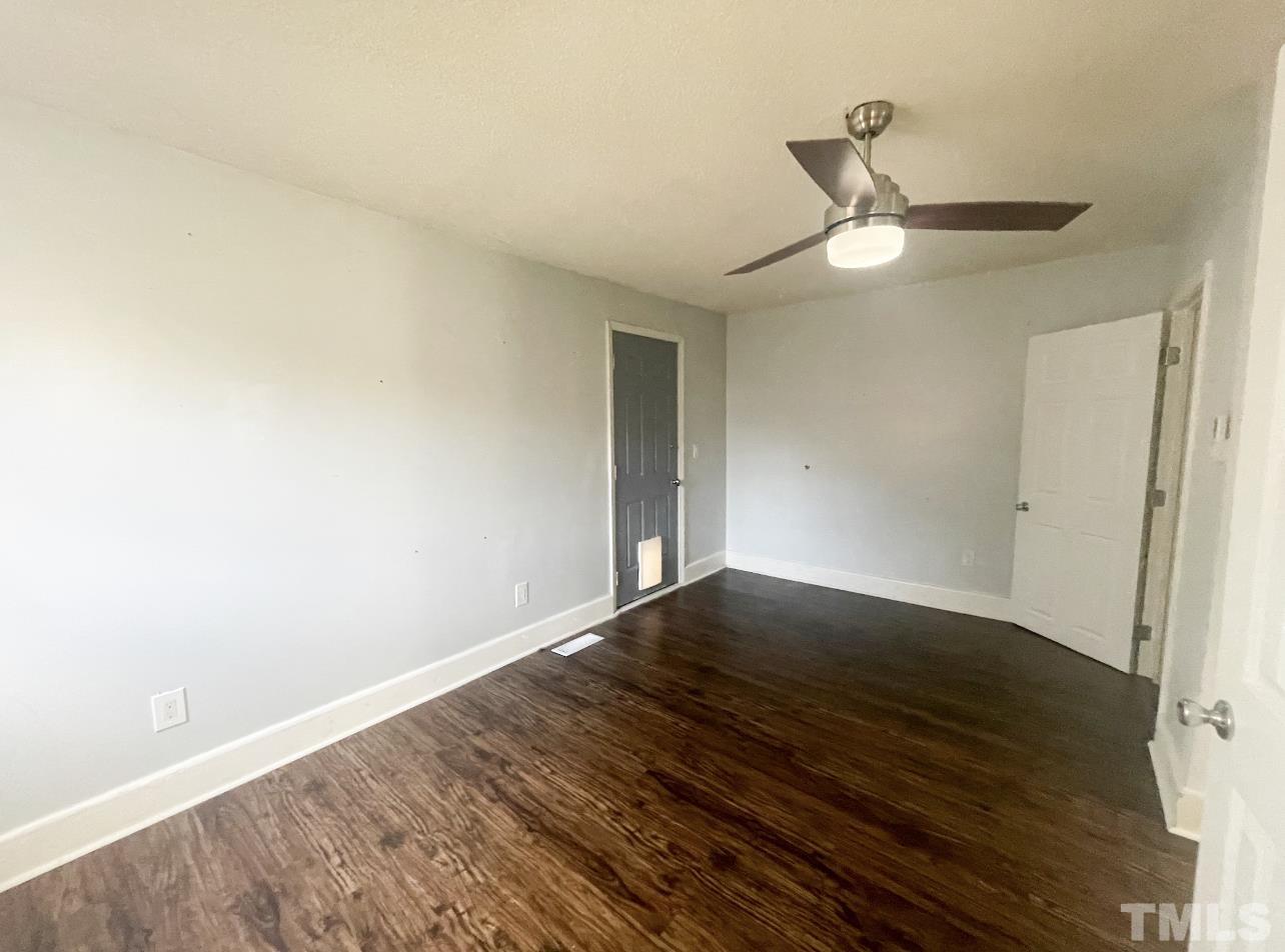1240 Pointer Street Roxboro, NC 27573 - Photo 17 of 20 a view of an empty room with wooden floor and a ceiling fan