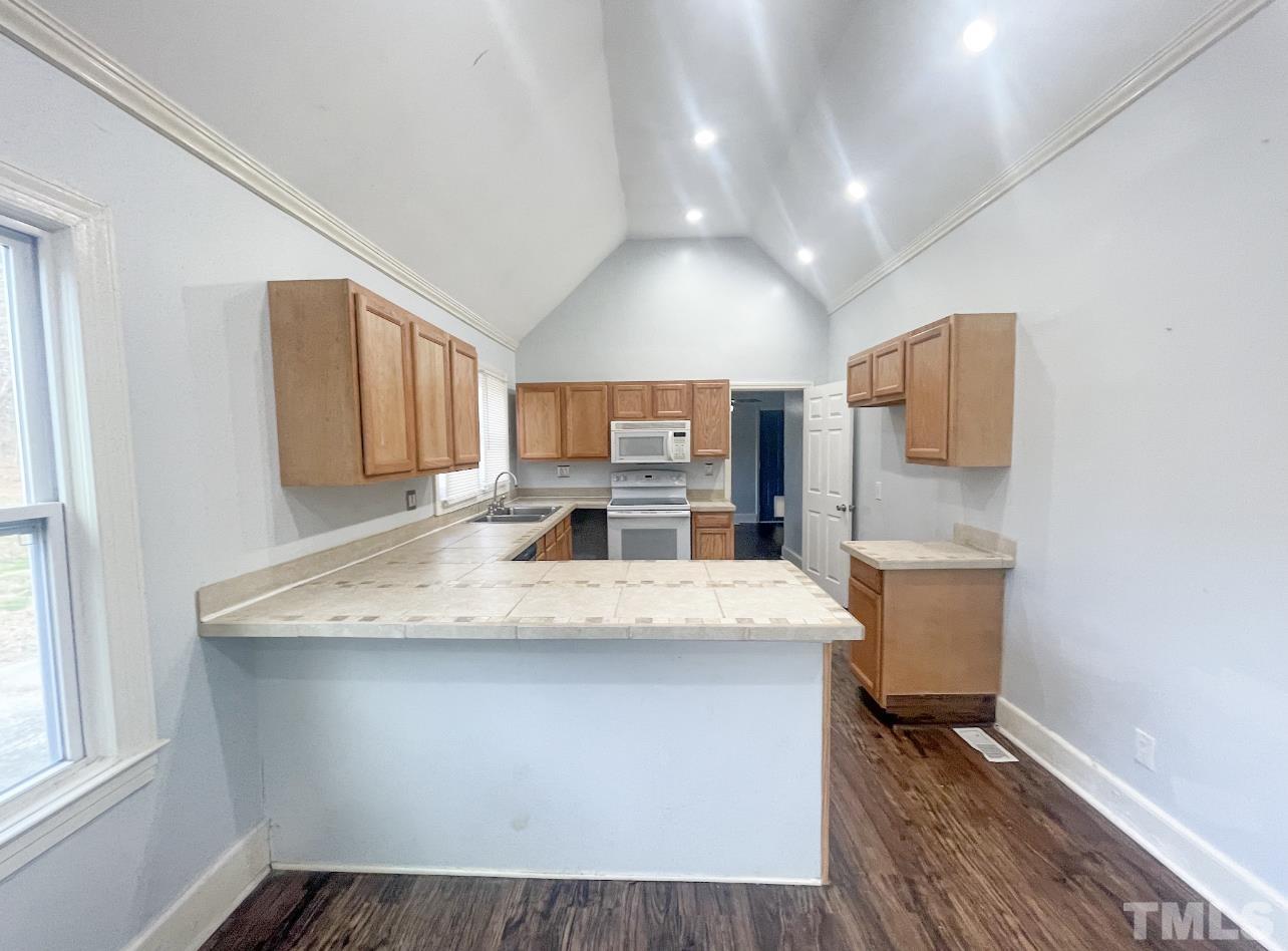 1240 Pointer Street Roxboro, NC 27573 - Photo 8 of 20 a room with a sink dishwasher and a refrigerator with wooden floor