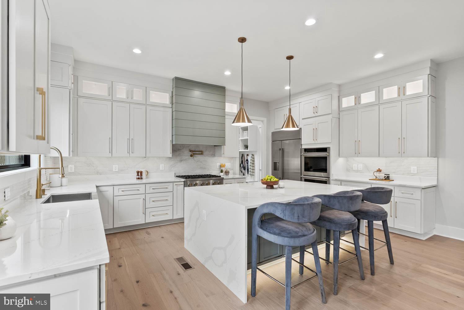 402 Marshall Road Southwest Vienna, VA 22180 - Photo 16 of 78 a kitchen with kitchen island granite countertop a sink a stove a refrigerator and white cabinets with wooden floor