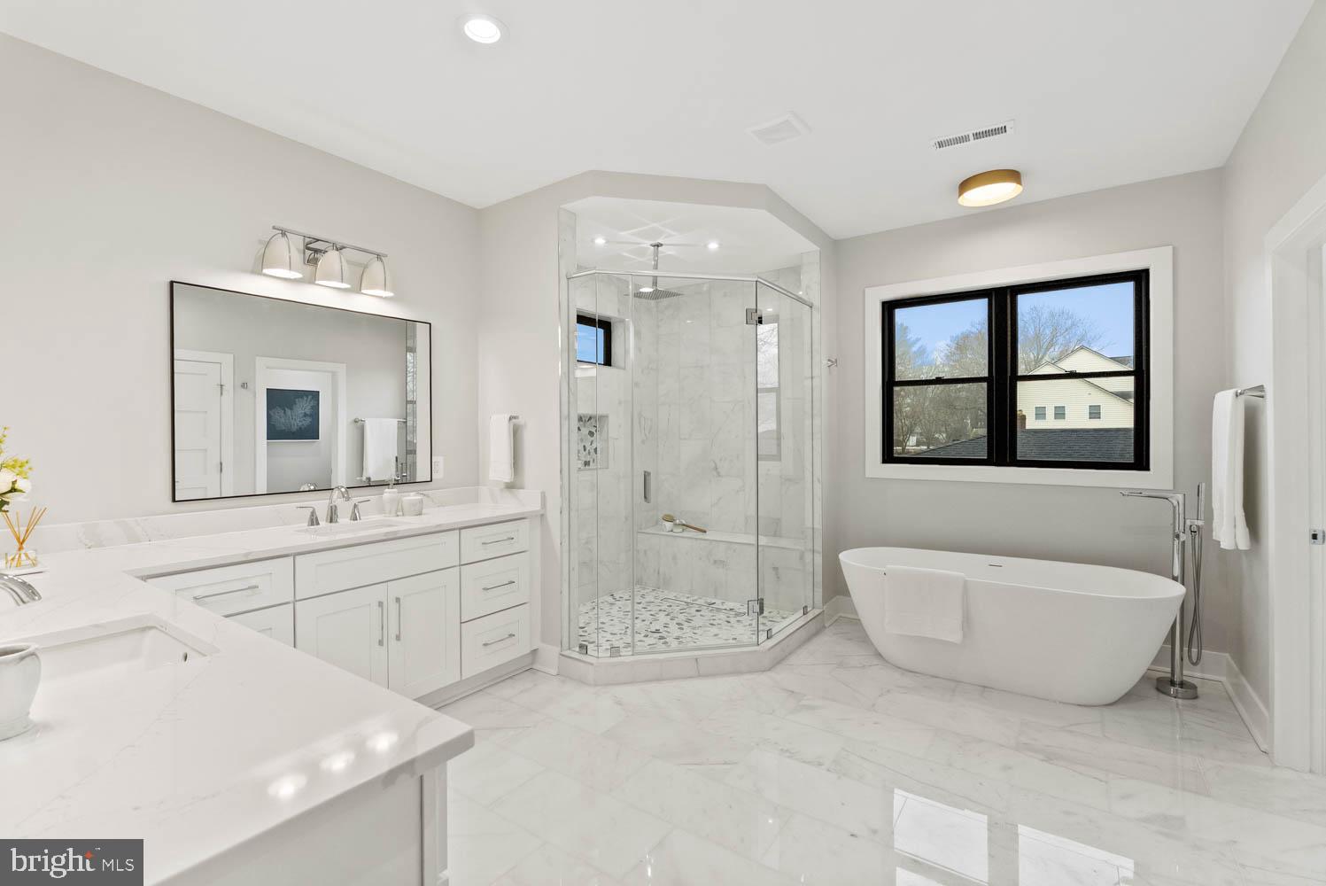 402 Marshall Road Southwest Vienna, VA 22180 - Photo 39 of 78 a spacious bathroom with a double vanity sink a mirror and a bathtub