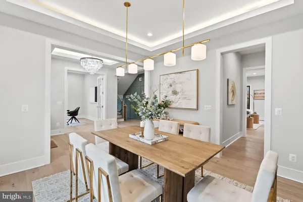 a living room with couches and kitchen view with wooden floor