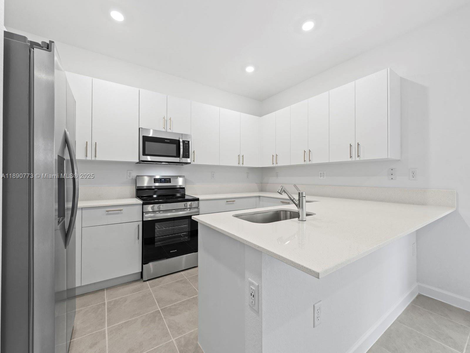 1525 Southeast 27th Street Homestead, FL 33035 - Photo 7 of 9 a kitchen with a sink a stove and refrigerator