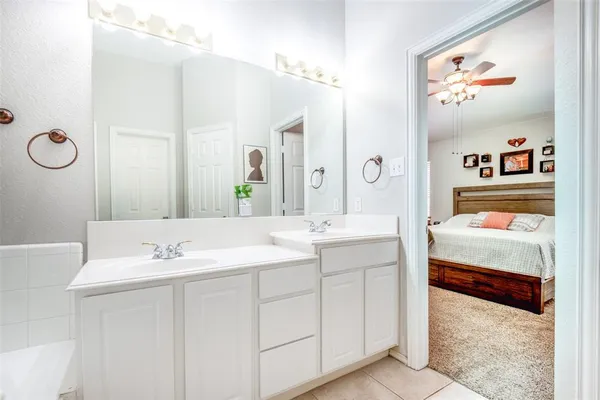 a en suite bathroom with a double vanity sink and a mirror