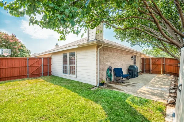 a view of a house with a yard and wooden fence