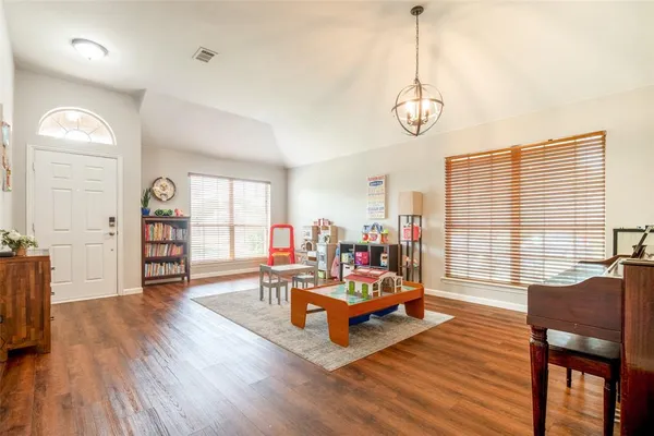a living room with furniture a window and wooden floor