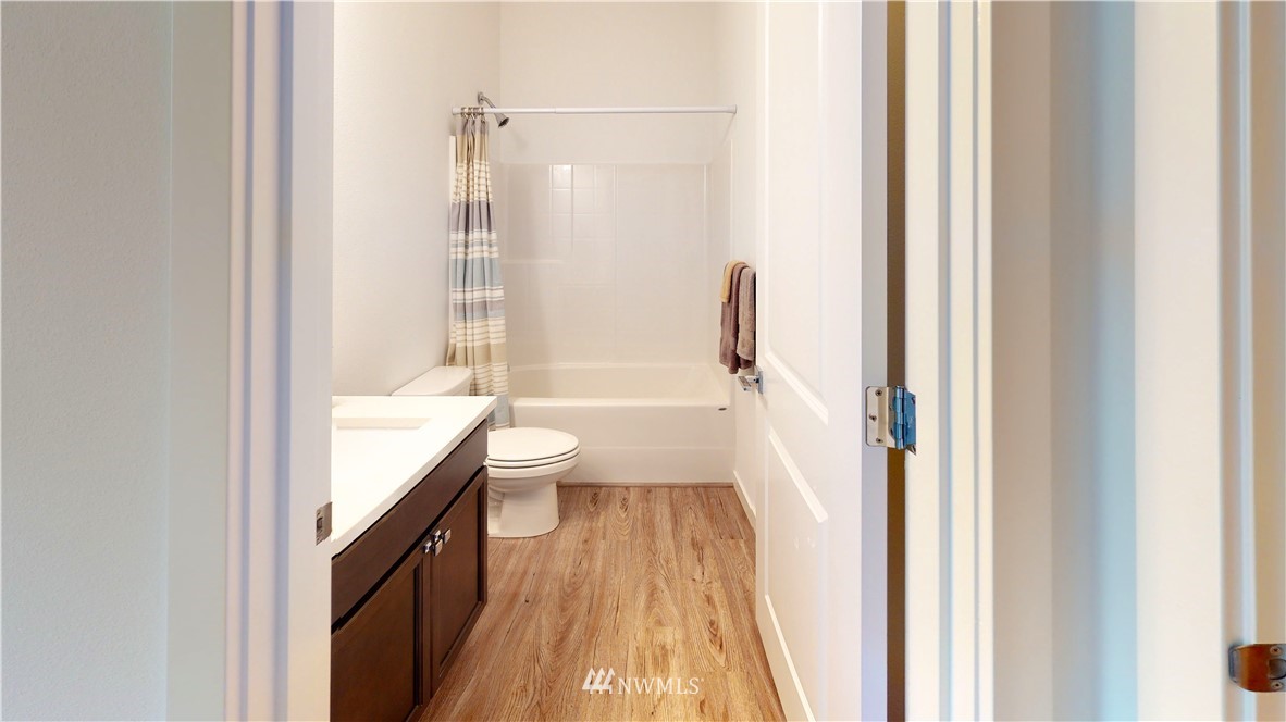 4861 Talbot Road South, Unit B3 Renton, WA 98055 - Photo 24 of 36 a bathroom with a granite countertop bathtub shower sink and toilet