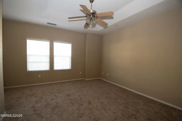 an empty room with a window and a ceiling fan