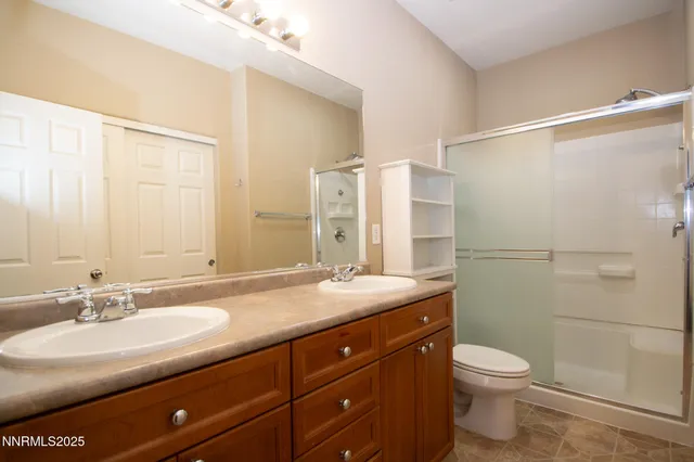 a bathroom with a granite countertop sink a toilet and shower